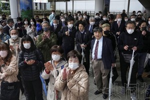 日本第20届统一地方选举的政令市长选举发布公告，人们在聆听街头演讲。3月26日上午摄于JR大阪站。（图：共同社）