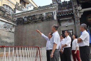 建筑单位代表向穗城会馆理事会介绍修葺浮雕和墙头画的步骤。