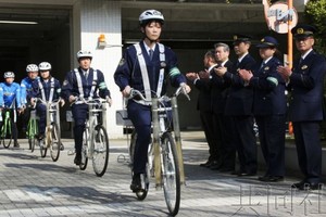 3月22日，警察戴着头盔、骑着自行车从东京警视厅月岛警署出发。（图：共同社）