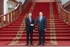 市人委会主席潘文迈（左）拜访老挝政府总理宋赛‧西潘敦。（图：瑞宇）