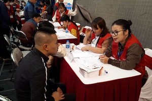 河内市就业劳务中心工作人员为残疾人士提供就业资讯。（图：朱良）