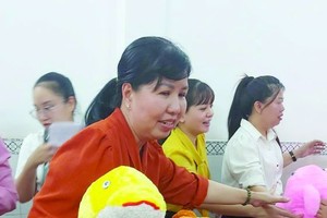 第五郡妇联会主席陈氏雪幸向残疾少儿赠送毛公仔。