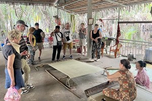 游客在槟椥省参观席子编织活动。