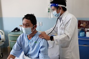 医生在为一名新冠患者进行肺部听诊。