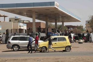 苏丹冲突持续，民众在一个油站等候领取物资。（图：AP）