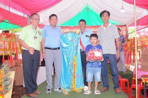 同奈省展邦县宝超城隍、观音庙理事会代表向黄泽邦先生（左二）移交“观音菩萨袍”。