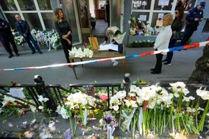 5月5日，在塞尔维亚贝尔格莱德，一名13岁男孩用父亲的枪杀死了 8 名同学和一名警卫两天后，一名女孩在案发学校前的吊唁簿上写下悼词。（图：AP）