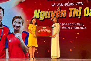 尤丽娟总经理将奖金转交给阮氏莺运动员(右)。