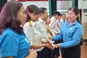 第五郡劳动联团主席黎氏碧幸颁奖给各单位代表。