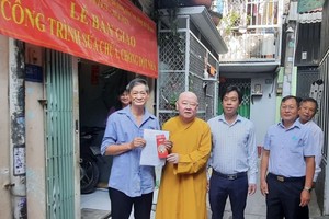 莲华寺住持释惟镇法师（左二）与地方领导向华人户移交“温情屋”工程。