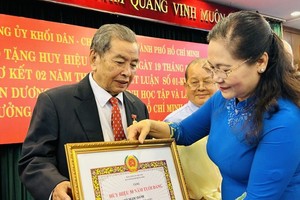 市委副书记、市人民议会主席阮氏丽颁发党龄纪念章。