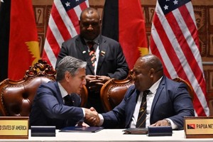 巴布亚新畿内亚防长达基（右）与美国国务卿布林肯签署协议，巴布亚新畿内亚总理马拉佩见证签署。（图：法新社）