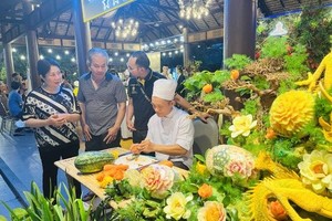 厨师在美食节上展示蔬果雕花艺术作品。