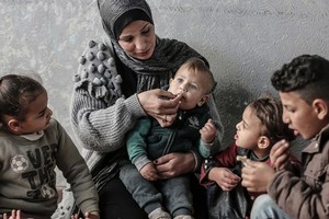 加沙的一个巴勒斯坦家庭分享用世界粮食计划署食品券购买的一顿饭。（图：联合国）