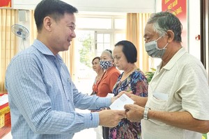 第五郡越南祖国阵线委员会主席黎晋才赠送礼物给老年人。