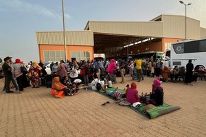 逃离苏丹冲突的人们在喀土穆的一个公共汽车站等待。（图：联合国）