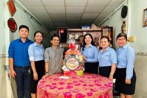 富润郡第九坊党委书记阮氏清草（右三）探望并向荣军赠送礼物。