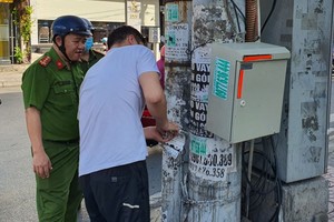 铃中坊公安强制一名年轻人自行清理其所张贴的广告传单。（图：明和）