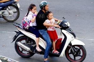 让孩子在摩托车前坐立，也不戴安全帽的情况很普遍，真的太危险了。