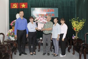 第八郡代表团向本报编委黎曰孟雄赠送鲜花。