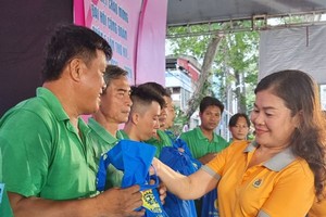 第五郡劳动联团主席黎氏碧幸向30名贫困业团团员赠送礼物。