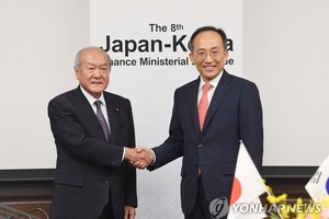 6月29日，在日本财务省大楼，韩国经济副总理兼企划财政部长官秋庆镐（右）和日本财务大臣铃木俊一出席第八届韩日财长会议，并握手合影。（图：韩联社）