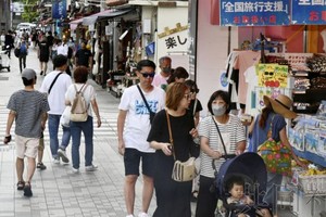 图为6月30日，冲绳县那霸市中心的大街上，人们往来交错。（图：共同社）