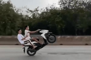 杨许黄云骑着摩托车载着阮文家杰翘头单轮行驶。（图：视频截图）