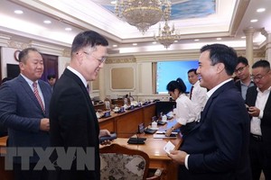 市人委会副主席裴春强(前右)与越南三星工程建设公司执行副总经理韩相德(音)交谈。（图：越通社）