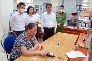 民众在芯片公民身份证上进行指纹生物识别。