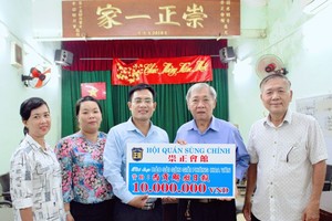 崇正会馆理事长郑鑫发和常值副理事长黄木锦向本报移交1000万元赠款。