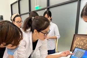 秋贤在修复画作。