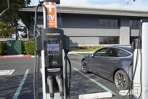 一架纯电动汽车及充电桩。（图：共同社）