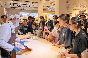 游客在西原科学研究院目睹观看艺人塑造巧克力的过程。