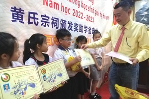 黄氏宗祠理事长黄锦雄向小学生们颁奖。