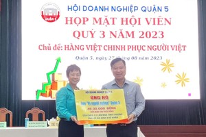 第五郡商会主席苏慧兰（左）将善款交给郡越南祖国阵线委员会领导。