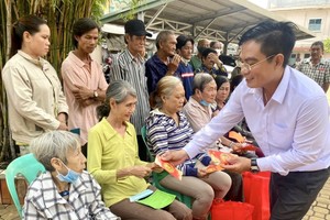 文忠孝编委向贫苦人家派发红包。