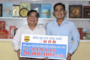 二府会馆理事长彭伟强将2000万元购买春刊经费交给本报编委文忠孝。