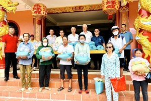 各理监事向贫困人家赠送济品。