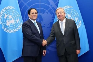 政府总理范明政（左）会见联合国秘书长安东尼奥•古特雷斯。（图：越通社）