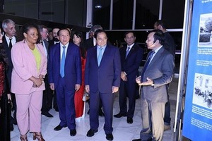 范明政总理和代表们参观关于胡志明主席和越南风土人情图片展。（图：越通社）