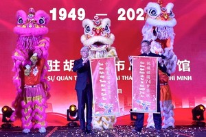 市人委会副主席武文欢（左）和中国驻本市总领事魏华祥接受贺语。