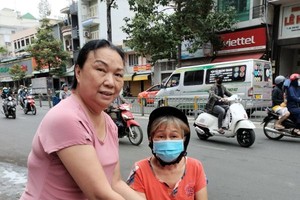 丽姐（左）向贫困妇女赠送礼物。