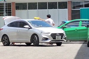 一名白色车牌司机接客上车后已拆掉了灯盒并准备将车驶出医院。