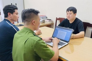 被捕的诈骗歹徒范越忠（黑衣）在公安派出所向调查员供述其犯罪过程。（图：警方提供）