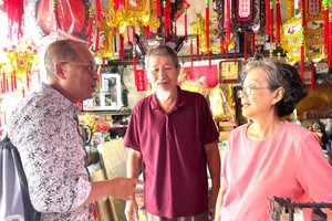 美国华人越侨叶家相（左一）与素未谋面的表姐许少芬（右一）相认。中间为林大顺书法家。