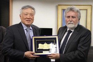 最高人民法院院长阮和平（左）向巴西联邦地区法院院长何塞·克鲁斯·马塞多赠送纪念品。（图：越通社）