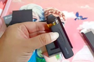 俊达在咖啡厅里使用外观犹如长形U盘的电子烟。