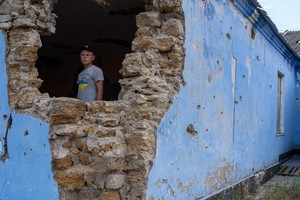 在乌克兰新霍里夫卡，一名男孩站在学校的废墟中。（图：联合国）
