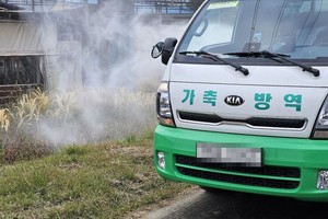 10月26日，在江原道横城郡的一养牛户入口，防疫部门进行消毒。（图：韩联社）